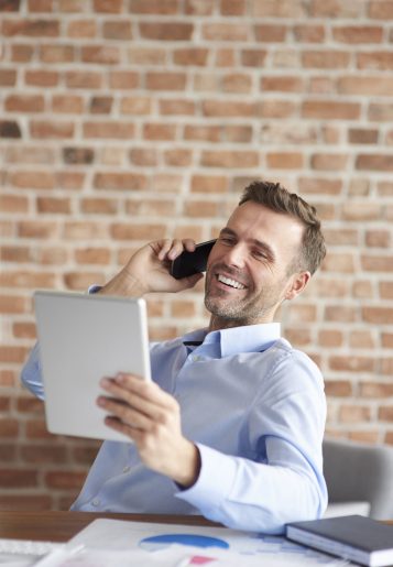 Talking on the phone and browsing digital tablet Talking on the phone and browsing digital tablet